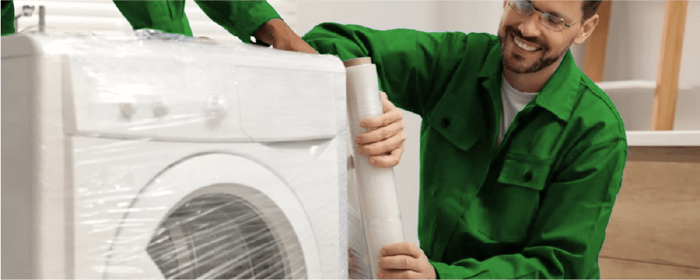 Foto van twee personen die samenwerken om een zware wasmachine te tillen